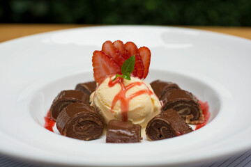 Chocolate pancakes crepe with ice cream and strawberries