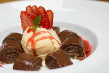 Chocolate pancakes crepe with ice cream and strawberries