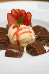 Chocolate pancakes crepe with ice cream and strawberries