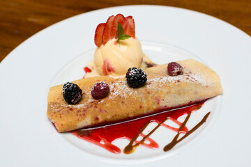 Crepe pancakes with strawberries and ice cream