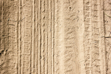 The texture of the sandy road. Road sand. Yellow sand in the sun with car and footprints.Sand...