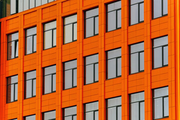 The facade of the new building is orange with dark-coloured windows