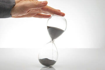 Hourglass on a light background. Time is money. Business solutions in time.