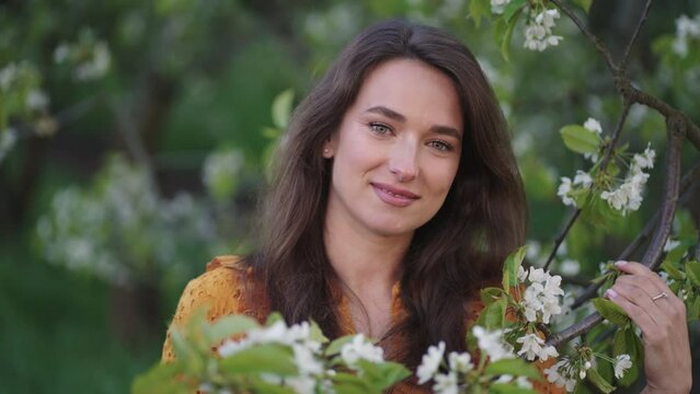 tender and innocent woman in blooming garden, portarit of pretty lady in orchard in spring day