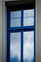 Single blue window with clouds reflection.