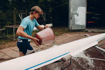 Sportsman single scull man rower prepare to competition with boat.