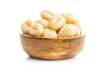 Uncooked potato gnocchi in bowl isolated on white background.