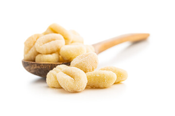 Uncooked potato gnocchi in wooden spoon isolated on white background.
