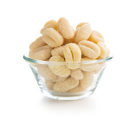 Uncooked potato gnocchi in bowl isolated on white background.