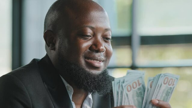 Successful african american rich businessman male investor accountant cashier counting personal earnings holding real payment salary stack money dollars win bet cash prize loan deposit monetary budget