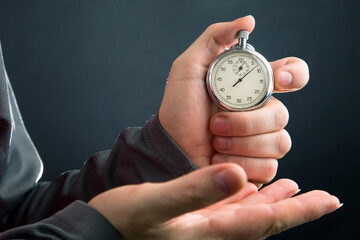 mechanical stopwatch in hand. Time part precision. Measuring the speed interval with a watch