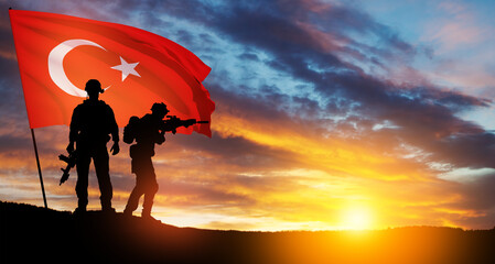 Silhouettes of soldiers with Turkey flag on background of sunset. Concept of crisis of war and...