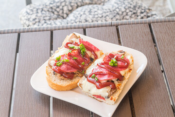 Tasty polish zapiekanka. Baguette with mushrooms, cheese and salami.