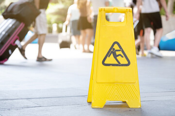 Yellow caution wet floor sign stands in airport