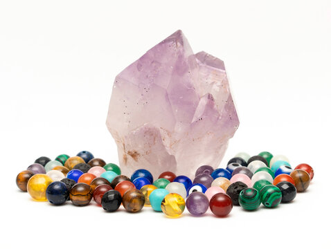 Piedra amatista junto a bolitas de piedra semipreciosas 