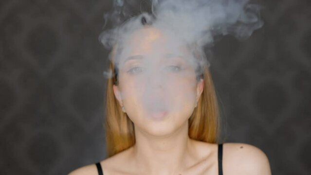 Young beauty blogger vaping vape in front of ring light.