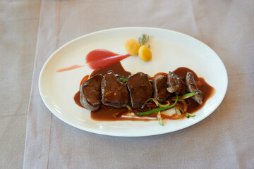 dish of venison tenderloins with sauce
selective focus