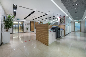 Bright office hall with floor tiles, furniture and office copy equipment.