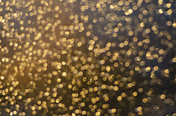 yellow, golden abstract background with bokeh,  glistening raindrops on glass at sunset
