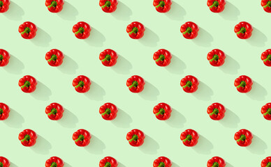 Pattern of red peppers on green pastel background