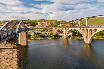 A steel bridge for pedestrians and two bridges for traffic cross the Douro River at Peso da Regua, Portugal