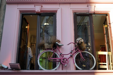 Rosa Fahrrad als Dekoration vor dem Fenster einer Boutique für Mode in Pink im Sommer bei...