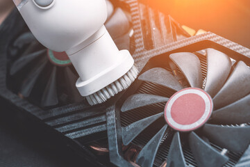 The master performs maintenance of a modern video card, cleaning the video card with a vacuum...