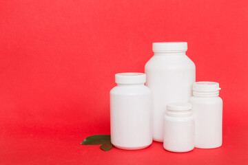 supplement pills with medicine bottle health care and medical top view. Vitamin tablets. Top view mockup bottle for pills and vitamins with green leaves, natural organic bio supplement, copy space