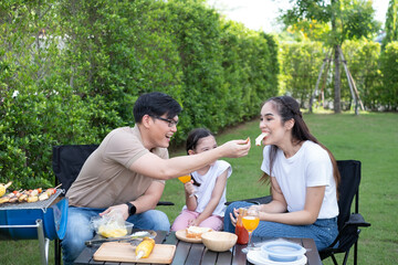 ..Asian family happy, party, BBQ in the backyard. funny family outdoor party leisure activity parents with child cute lovely happy smile at backyard.