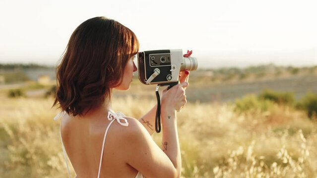 Woman filming the nature with vintage camera 