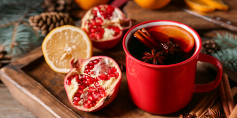 Mug of tasty mulled wine on table, closeup