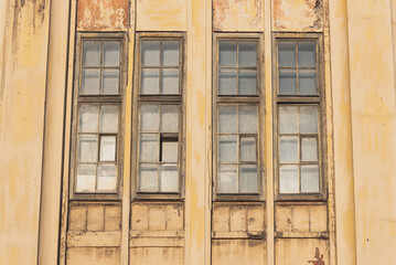 Narrow vertical windows of a century-old factory. Closeup, historic industrial architecture