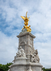 Fototapeta na wymiar London, England, UK - July 6, 2022: Victoria Memorial. Motherhood and Truth statue combinations share the front and golden Winged Victory on top under blue cloudscape.