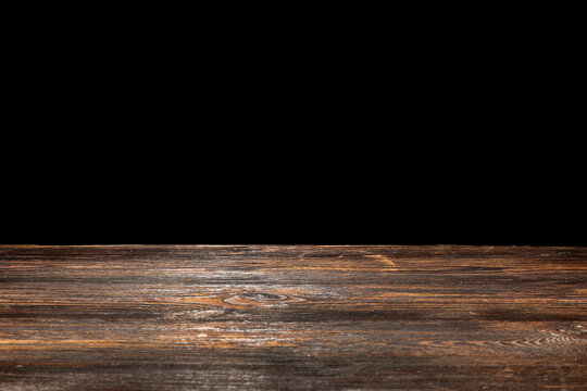 Wooden table top on black background