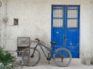 Fototapeta na wymiar A bicycle parked in front of a worn blue door