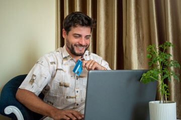 Hombre contento y conforme después de realizar una compra on-line con su computadora
