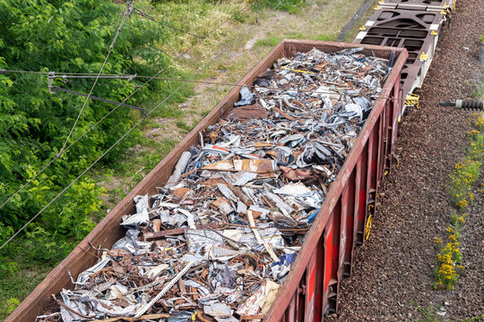 Above View Of Railway Cargo Train Wagon Filled By Old Rusty Black Metal Scrap Garbage Forfactory Plant Recycling. Steel Waste Collecting, Disposal Transportation Logistics. Environmental Protection