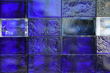 Glasbausteine werden häufig als Raumteiler und Fensterersatz genutzt. Die Farbe von dem Glasbaustein ist blau bis dunkelblau. Gerne werden diese Steine illuminiert. - obrazy, fototapety, plakaty