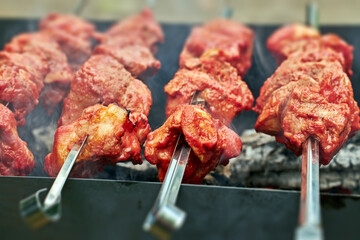 Meat skewers on coals. Smoke over pieces of meat on skewers close-up, selective focus.