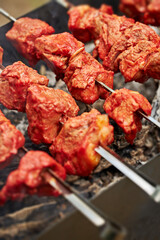 Meat skewers on coals. Smoke over pieces of meat on skewers close-up, selective focus.