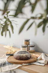 Board with fresh bread on kitchen counter near grey wall