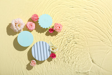 Decorative stands and flowers in water against yellow background