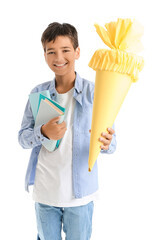 Little boy with yellow school cone and books on white background