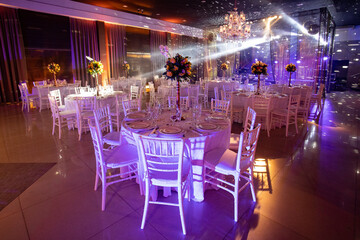 table set in night party hall with scenic lights, beam of light