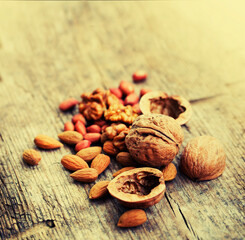 various types of nuts closeup over wooden background 