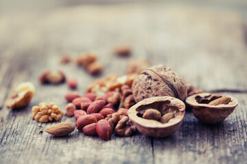 various types of nuts closeup over wooden background 