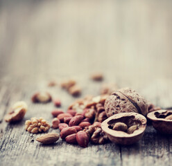 various types of nuts closeup over wooden background 