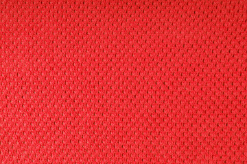 Close up background of knitted wool fabric with dots pattern. Bright red color wool knitwear...