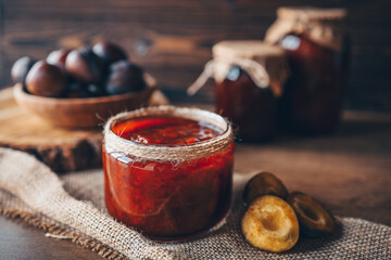 Glass jar with delicious homemade plum jam on table