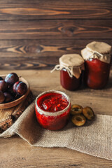 Glass jar with delicious homemade plum jam on table